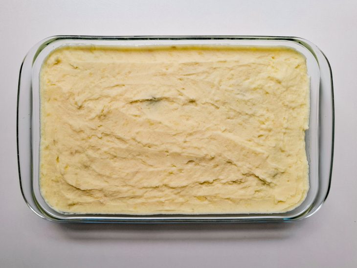Camada de purê de batata por cima do recheio.