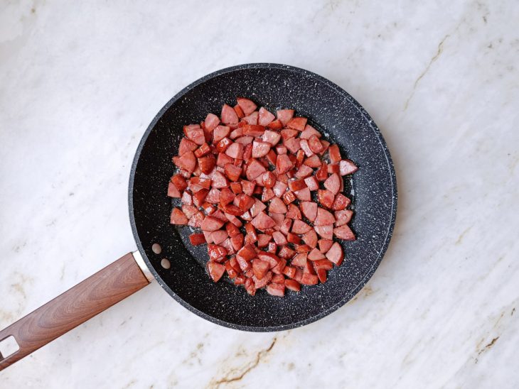 Calabresa dourando em frigideira com um fio de azeite.
