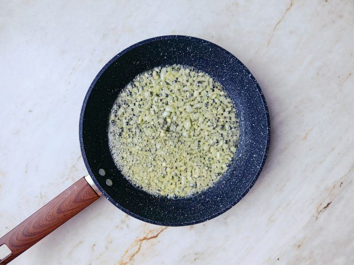Manteiga, cebola e alho refogando para o início do molho branco.