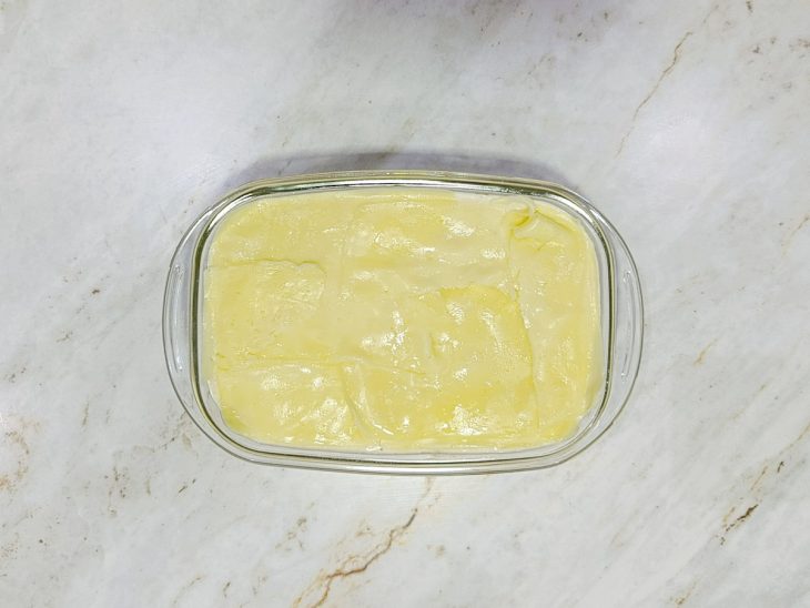 Molho branco e queijo fatiado adicionados por cima do recheio.