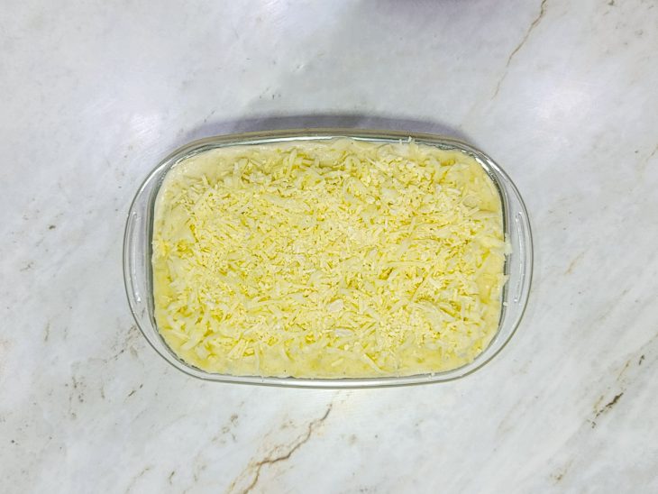 Segunda camada de purê finalizada com queijos ralados.