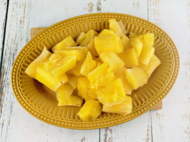 Mandiocas cozidas reservadas em um prato oval amarelo.