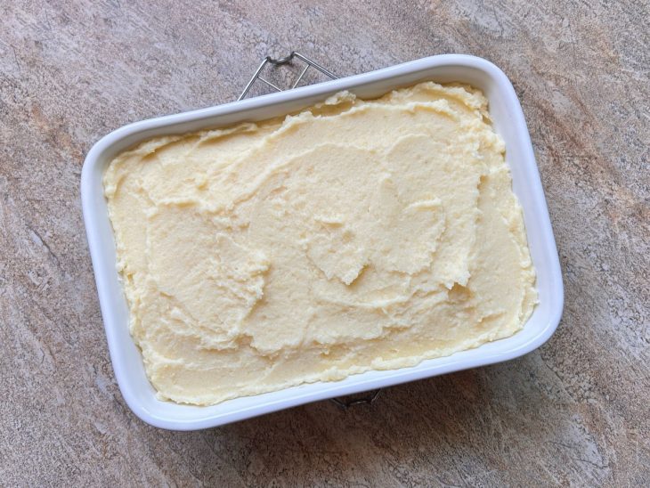 Na travessa, creme de batata distribuído uniformemente.