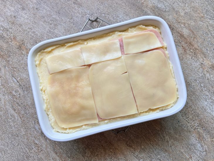 Na travessa, uma última camada de presunto e queijo.