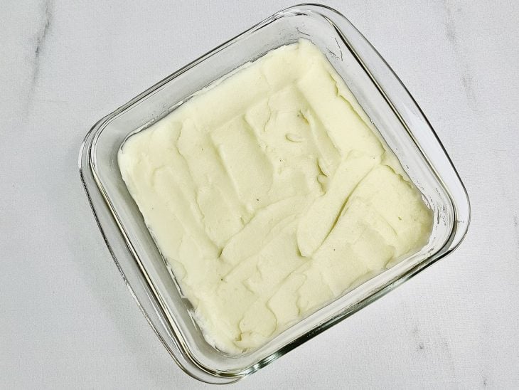 Camada de purê de batatas acomodada em um refratário.