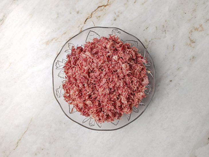 Charque desfiada com um garfo.