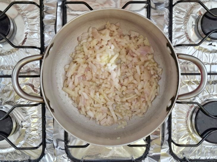 Margarina, cebola e sal em uma panela.