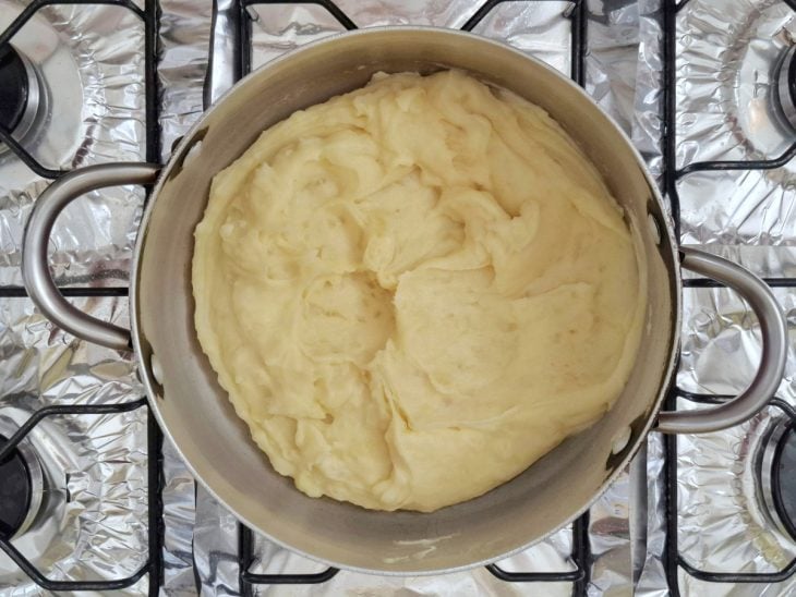 Batata, leite e temperos adicionados e incorporados na panela.