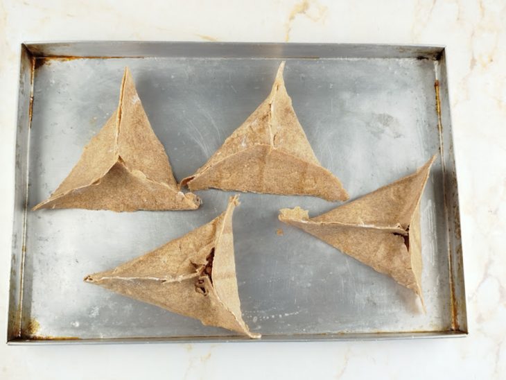 Esfihas modeladas numa assadeira.