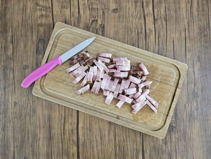 Uma tábua com bacon cortado em tirinhas.
