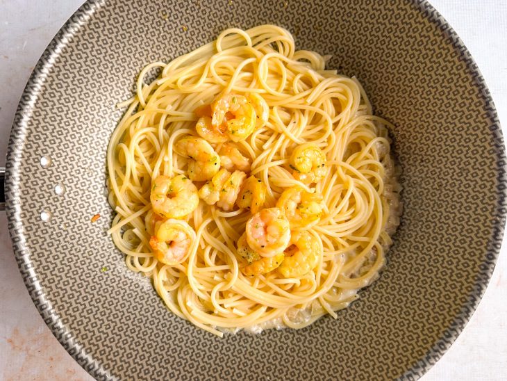 Macarrão e camarão na panela.