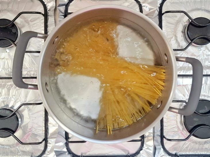 Macarrão cozinhando em uma panela com água e sal.