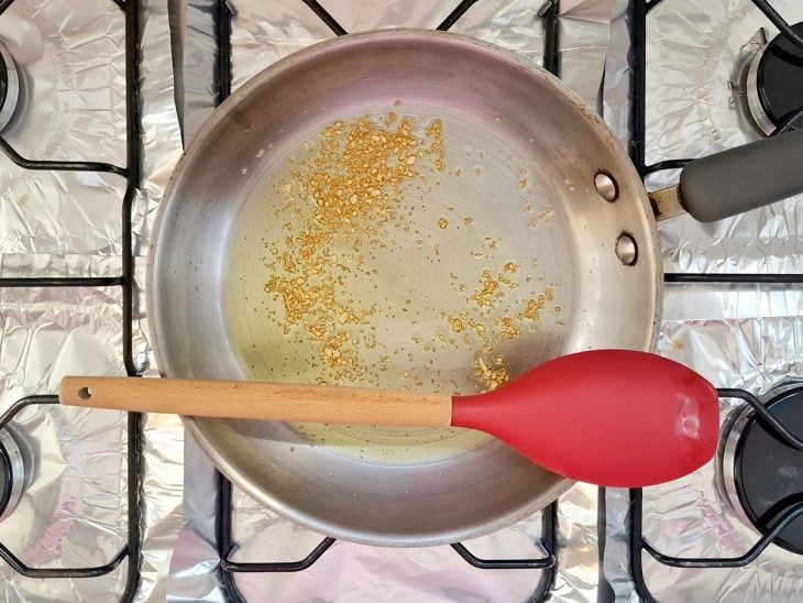 Alho refogado em uma frigideira com azeite.