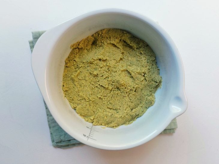 Um recipiente contendo a mistura de bicarbonato, farinha de trigo e massa de grão-de-bico.