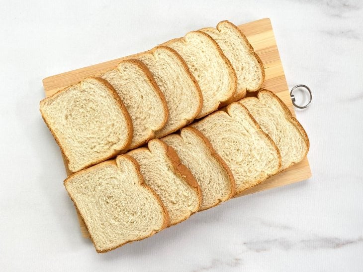 Fatias de pão de forma em uma tábua para a receita de farinha Panko caseira.