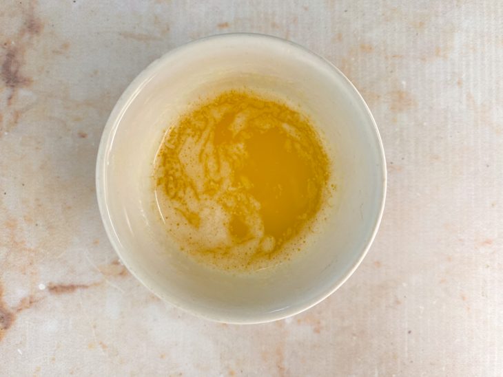 Numa tigela, a manteiga de garrafa aquecida.