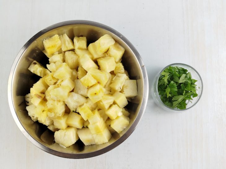 Abacaxi cortado em cubos e escorrido em peneira.
