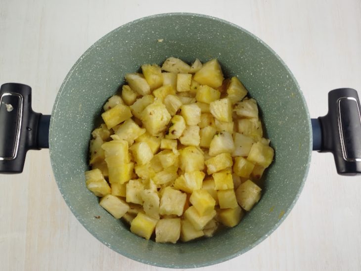 Cubos de abacaxi dourados na frigideira.