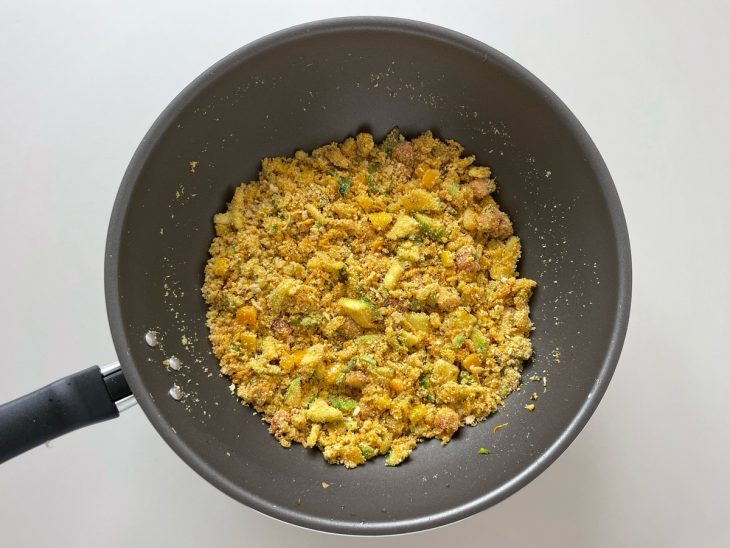 Legumes e temperos sendo adicionados e misturados ao refogado.