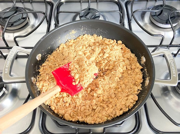 Uma frigideira com farinha de mandioca, amendoim, manteiga e sal.