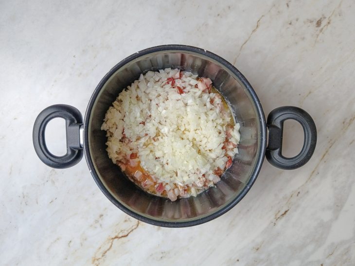 Bacon e cebola fritando na panela.