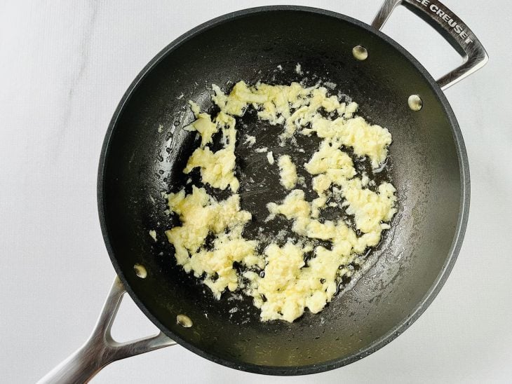 Manteiga, cebola e alho refogados na mesma frigideira.