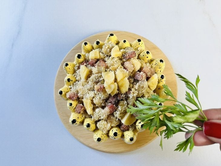 Farofa de banana com bacon finalizada com ervas.