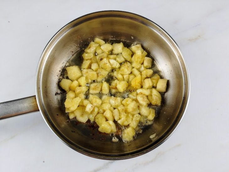 Bananas fritando em uma frigideira com azeite.