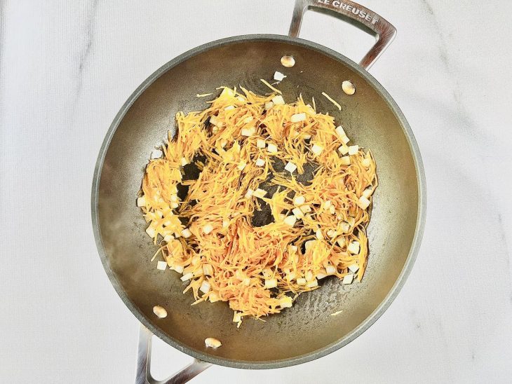 Cenoura ralada e água adicionada na panela.