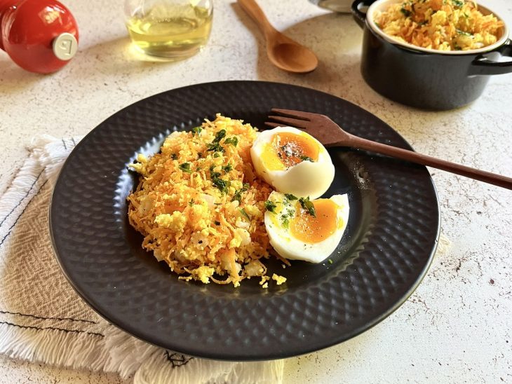 Farofa finalizada com cheiro-verde e servida com ovos.