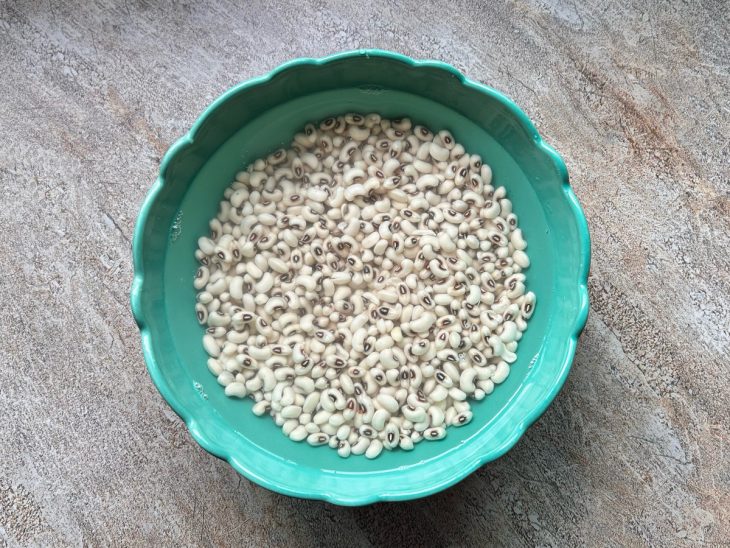 Feijão de molho em uma tigela com água fervente.