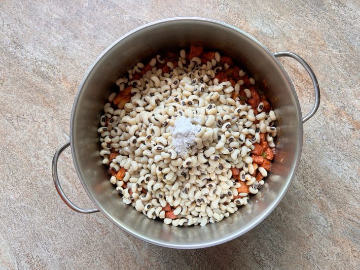 Feijão-fradinho e sal adicionados na panela.