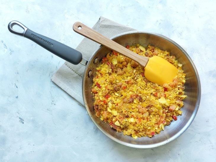 Tomate e farinha de milho adicionada na frigideira.