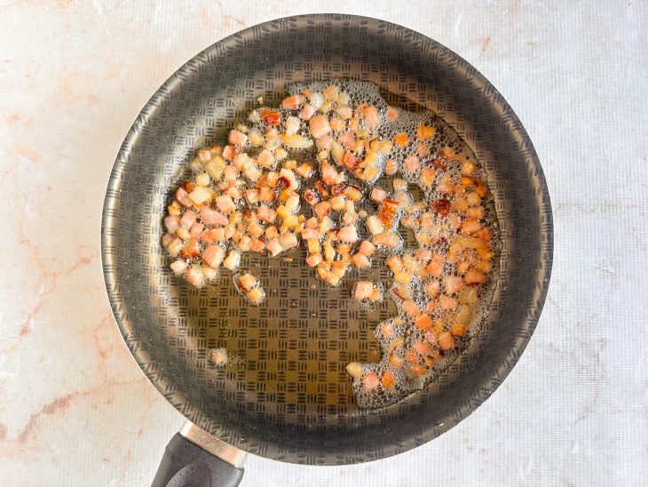 Bacon frito na frigideira.