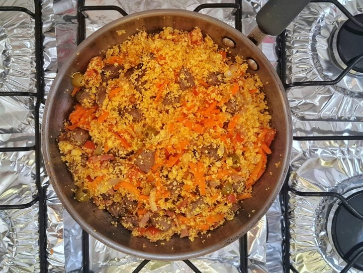 Panela com a mistura de todos os ingredientes da farofa ao fogo.