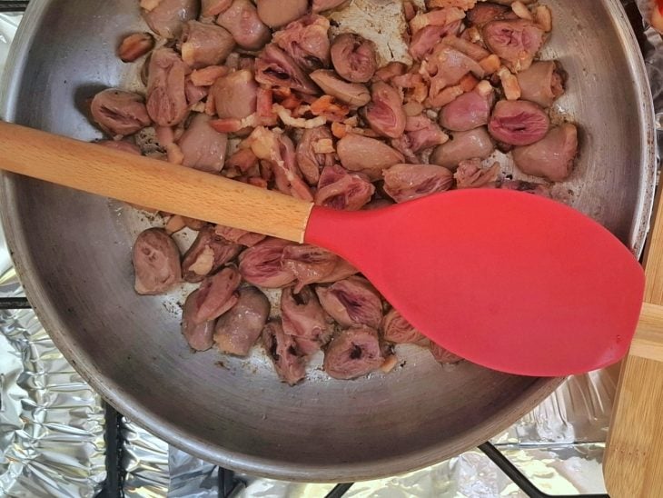 Uma panela com coração de galinha refogando.