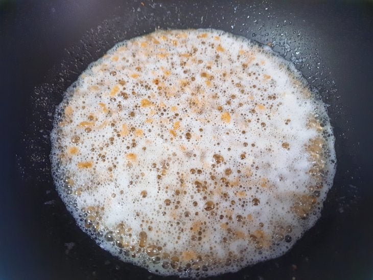 Uma frigideira com óleo, creme de cebola e PTS.