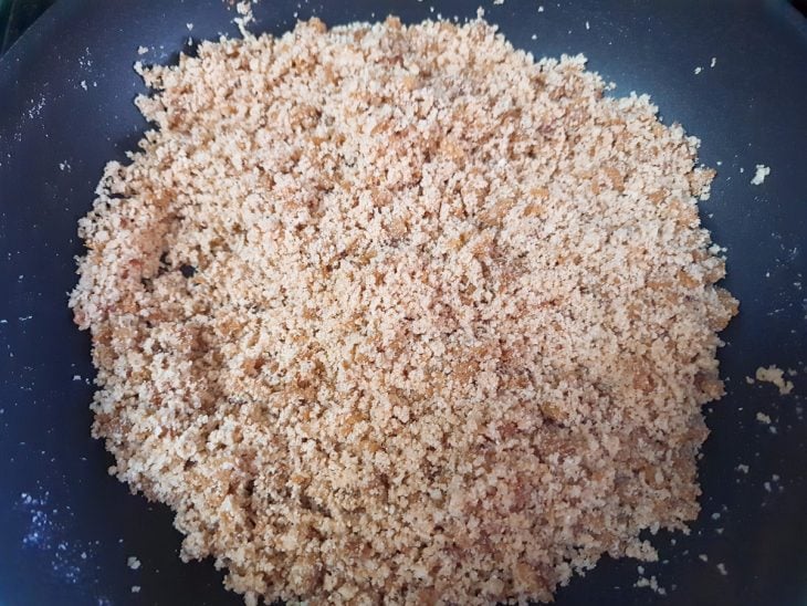 Uma frigideira com óleo, creme de cebola, PTS e farinha de mandioca biju.