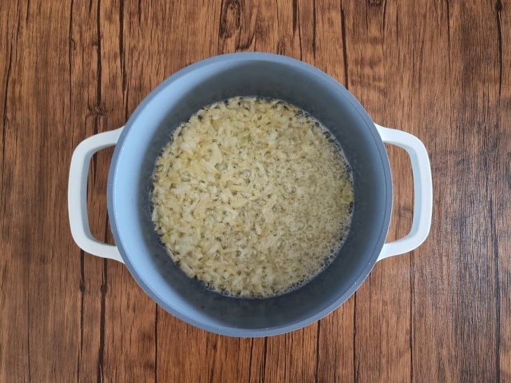 panela com cebola picada e gorduras refogando.