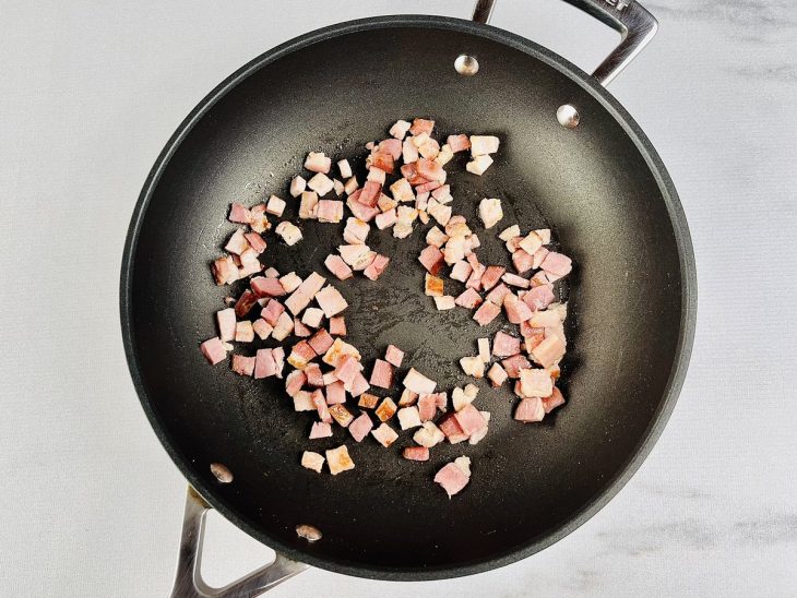 Na panela, o bacon fritando.