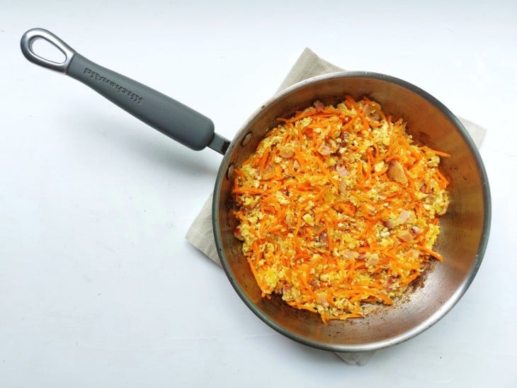 Frigideira com a cenoura ralada adicionada ao restante dos ingredientes.
