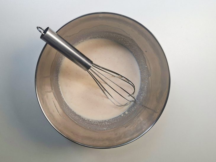 Massa líquida inicial sendo misturada com leite morno e farinha.