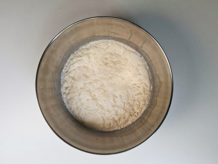 Massa fermentando coberta com pano até espumar.