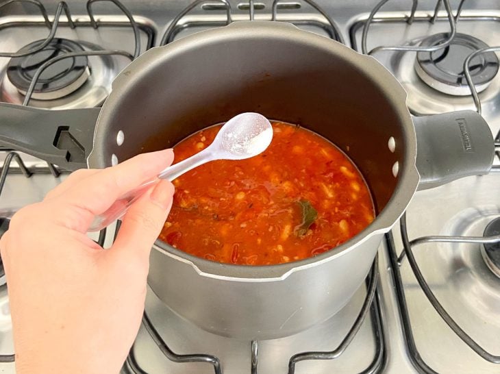 Uma panela contendo feijão-branco com molho de tomate.