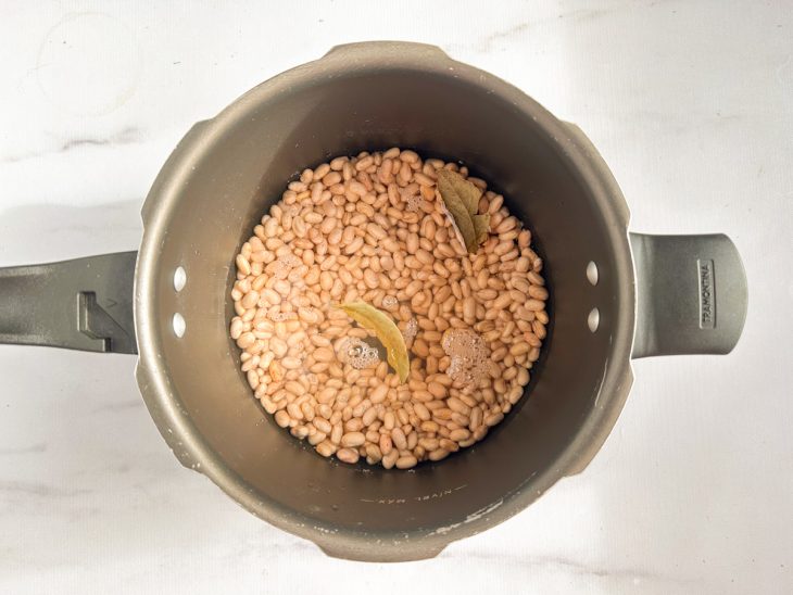 Feijão cozinhando na panela.