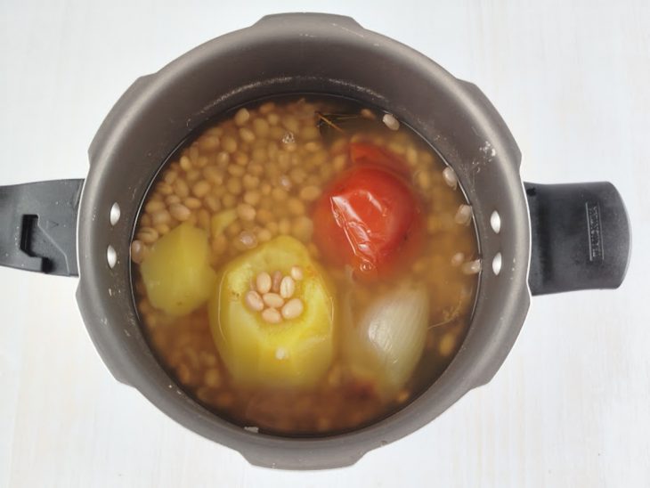 Feijão cozido sendo aberto após pressão.