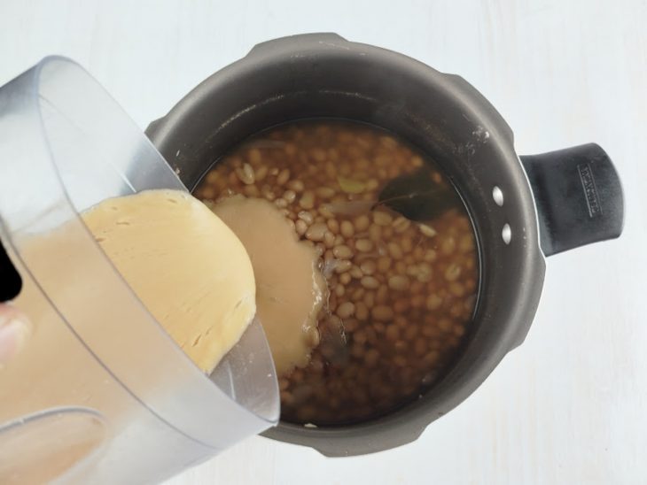 Creme sendo devolvido à panela com o feijão.