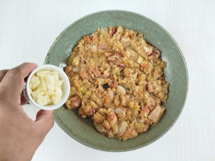 Alho sendo adicionado ao refogado para dourar.