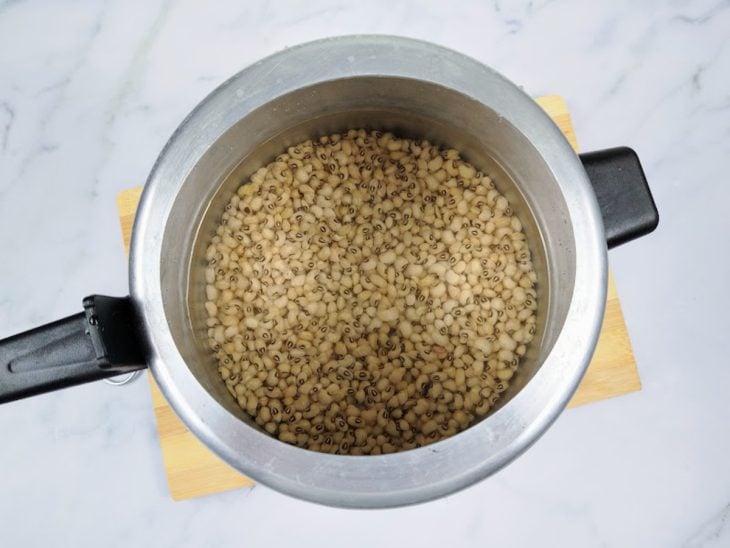 Uma panela de pressão com feijão e água.