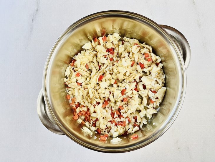 Pimentão e bacalhau adicionados na panela.